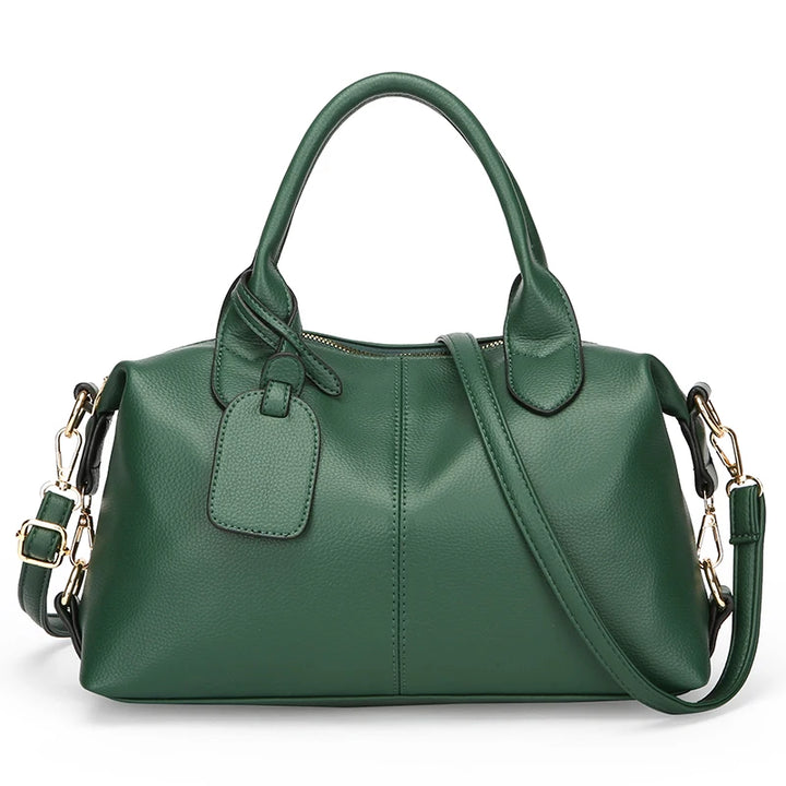 Dark green soft leather tote bag with top handles, front luggage tag, and shoulder strap