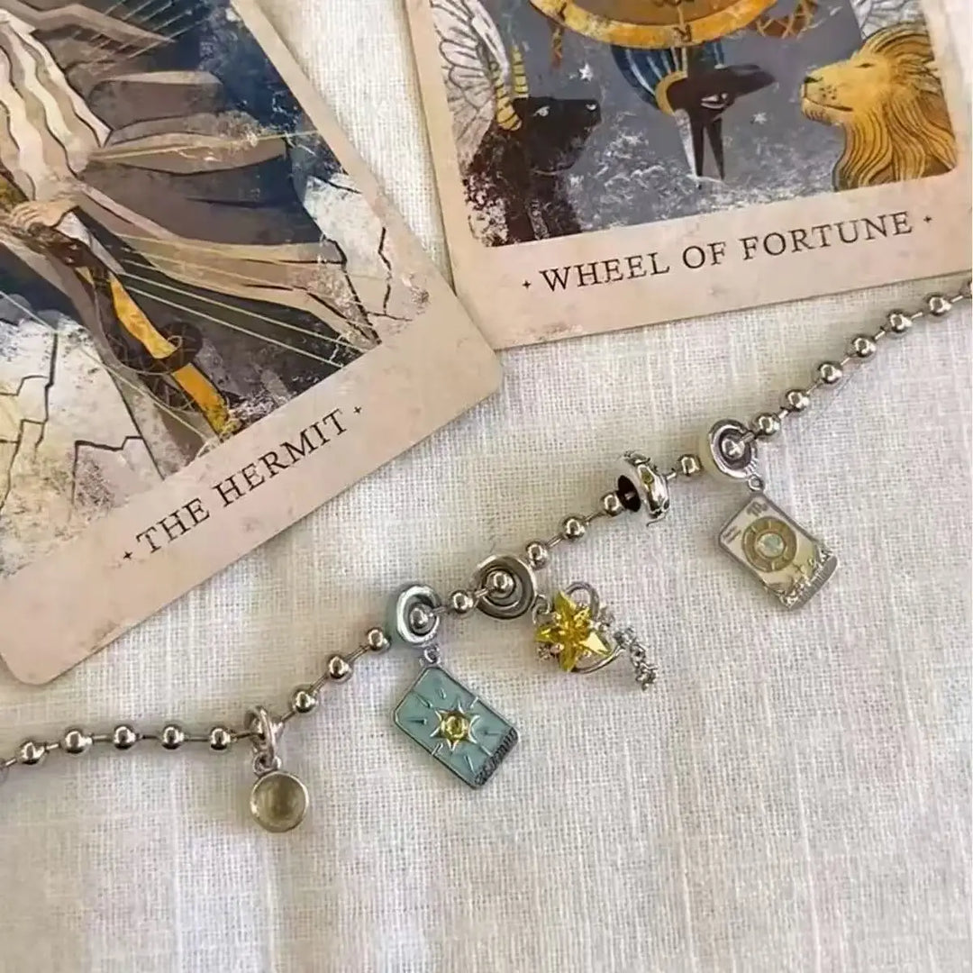 Bracelet with charms on tarot cards 'The Hermit' and 'Wheel of Fortune'.