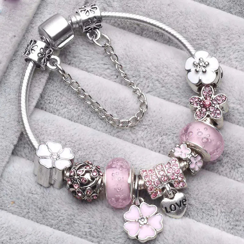 Silver bracelet with pink bead charms, flower spacers, and LOVE heart medallion