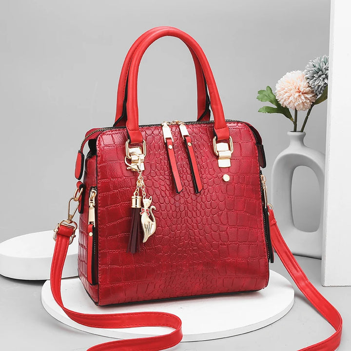Red handbag with gold accents on a gray background