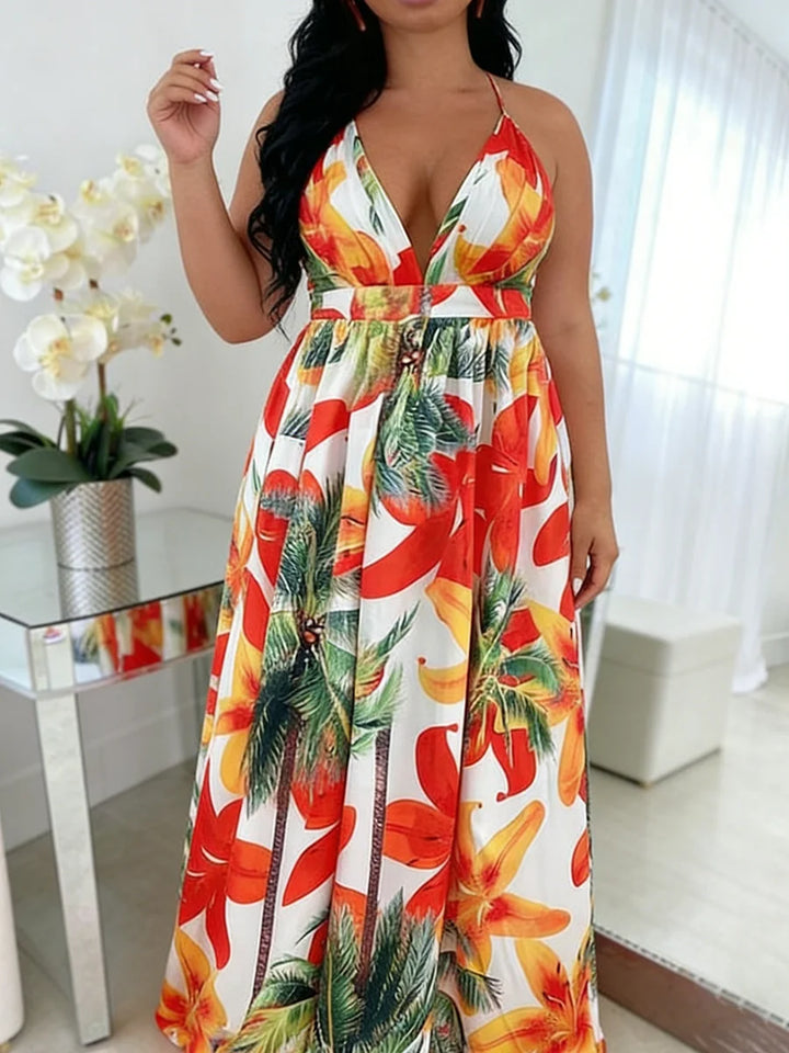 Woman wearing a colorful floral dress in a room with a table and flowers.