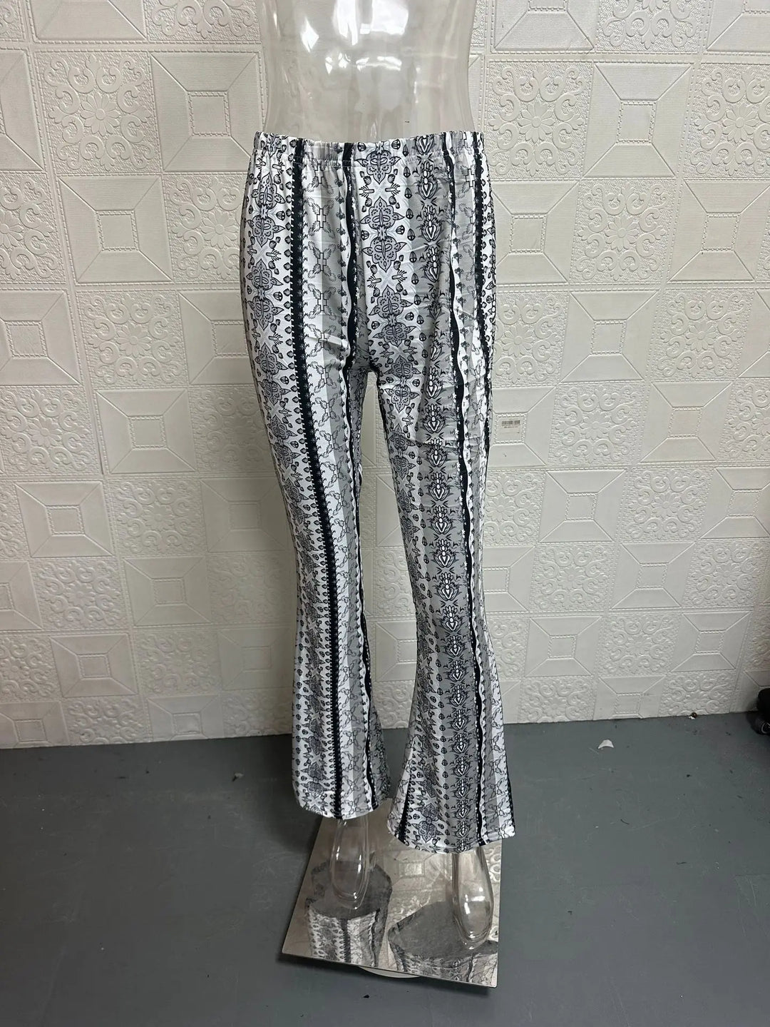 Low-waist flare pants with black-and-white vertical scroll print and wide legs