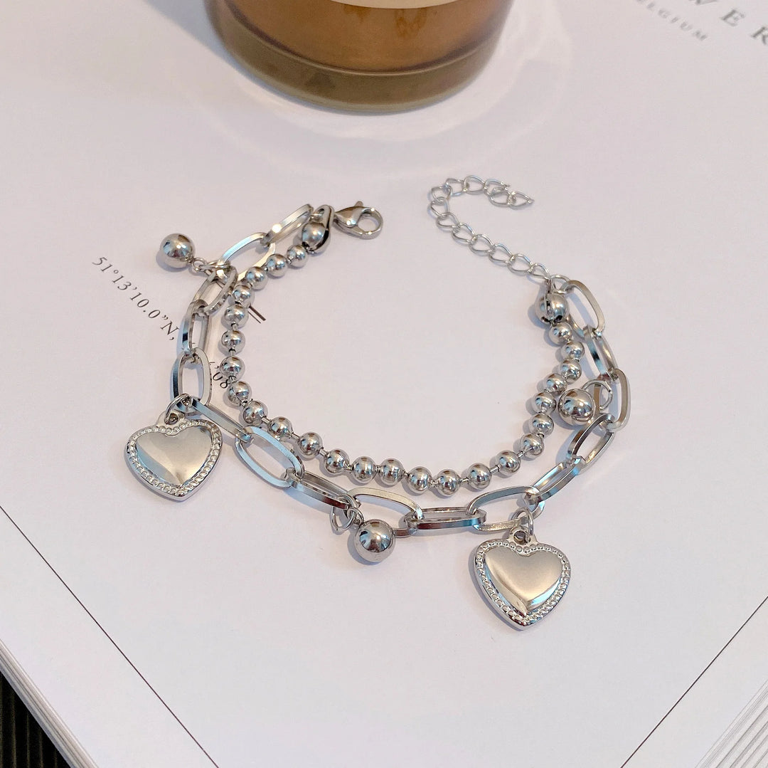 Silver bracelet with heart charms on a white surface