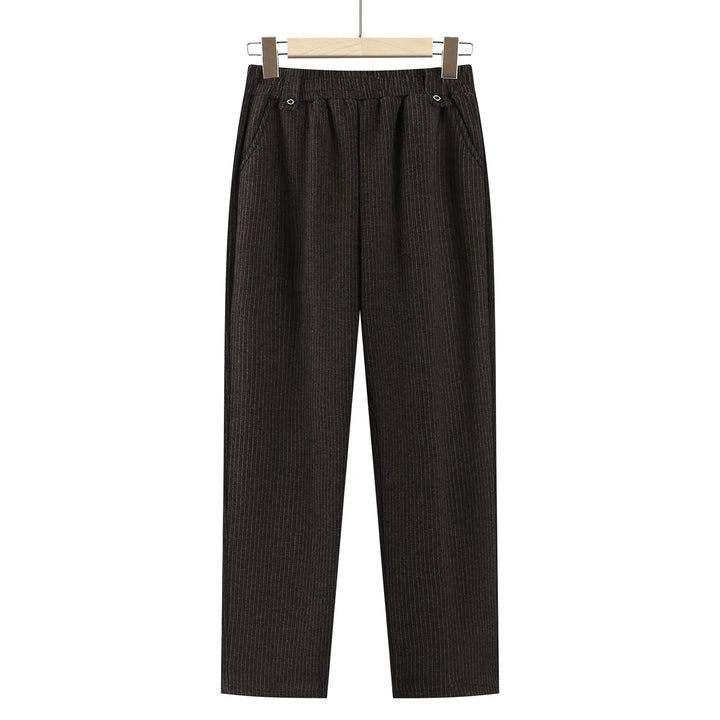 Dark brown vertically ribbed wide-leg cropped pants with an elastic waistband and button details, hanging on a wooden hanger against a white background.