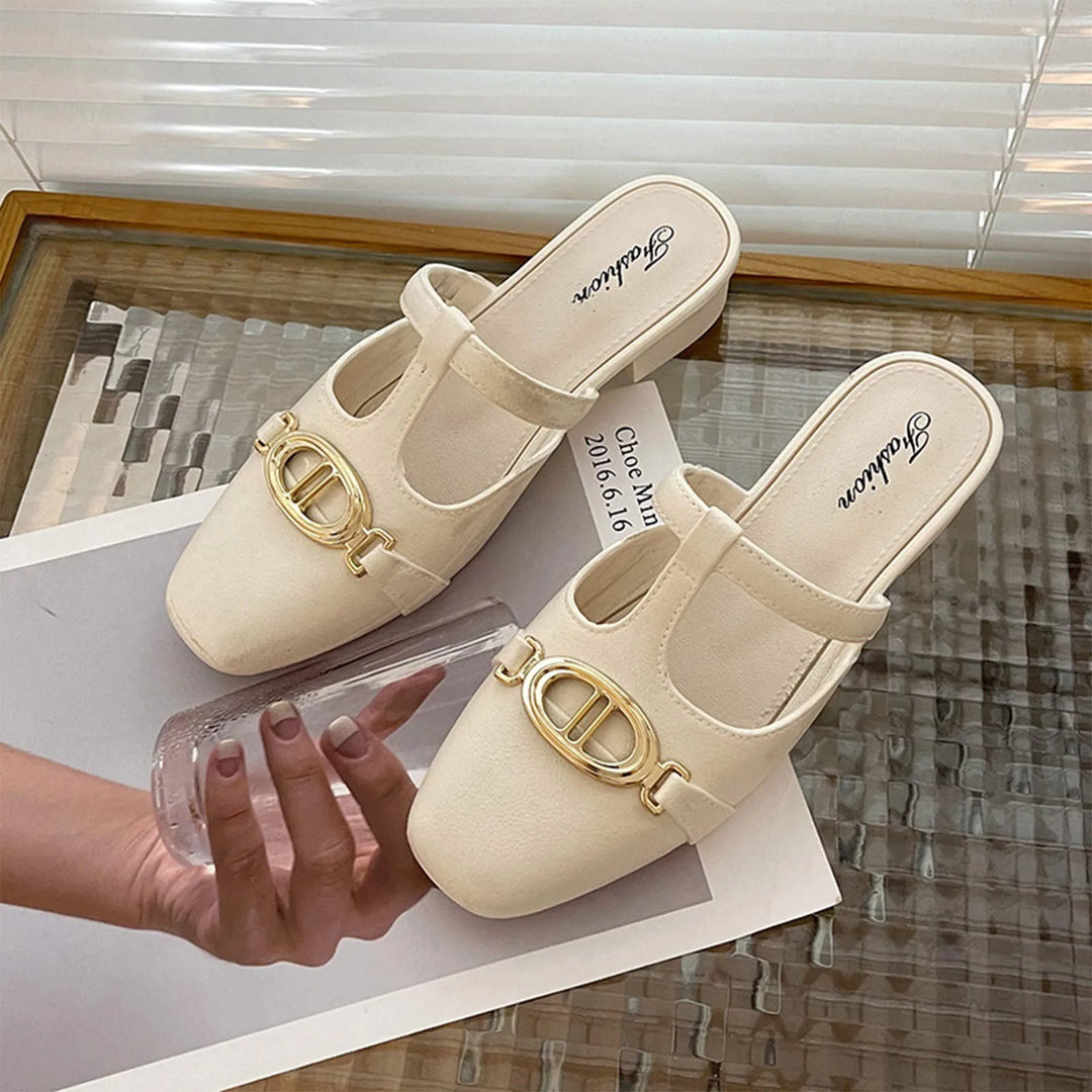 Beige shoes with gold accents on a reflective surface