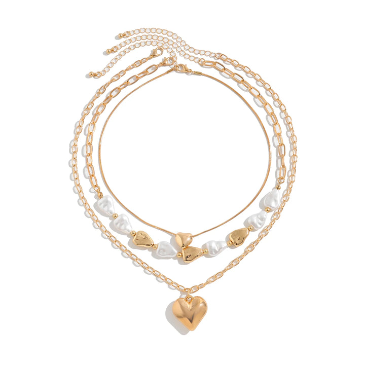 Set of gold and pearl necklaces on a white background