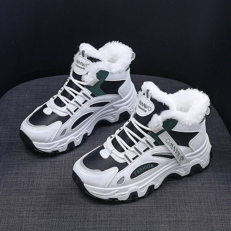 Pair of white and black winter sneakers with fur lining on a dark background