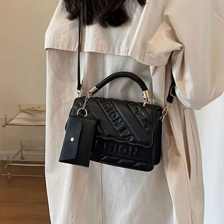 Women’s quilted crossbody bag in black worn on shoulder with mini coin pouch