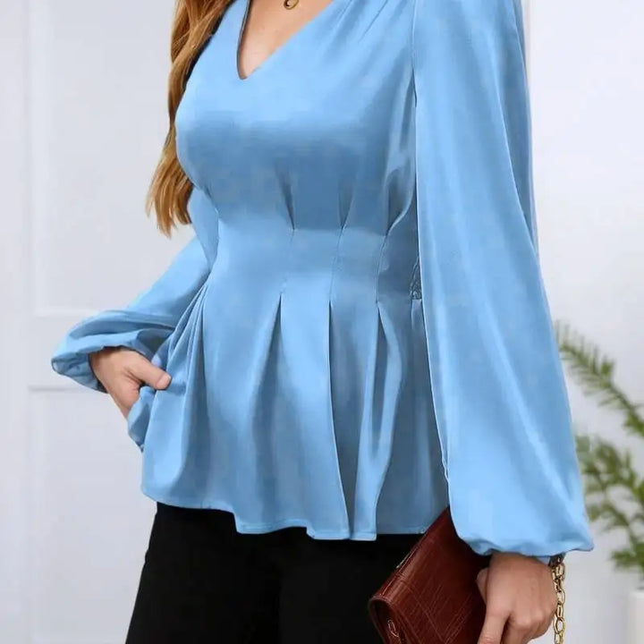 Light blue peplum top worn by a person with a blurred background
