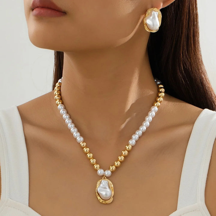 Pearl necklace with gold accents worn by a model against a neutral background