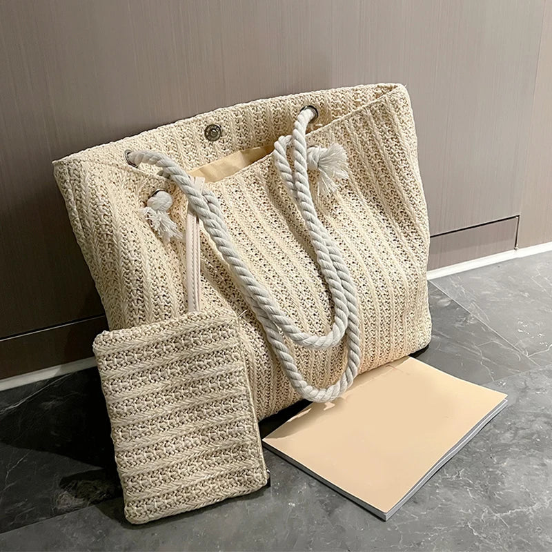 Beige woven tote bag with rope handles on a dark surface