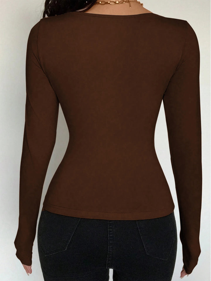 Brown long-sleeve top worn by a person on a white background