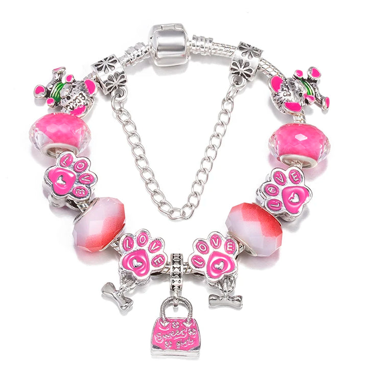 Silver charm bracelet with pink heart and paw-print charms, faceted beads, and handbag charm