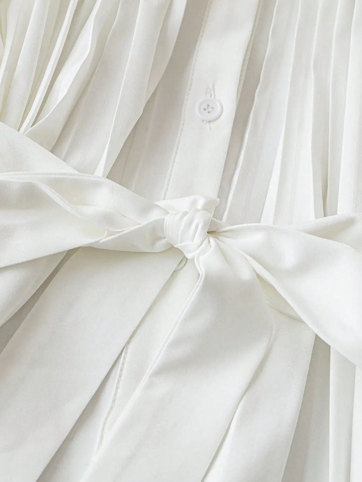 White pleated button-up shirt with front button and bow-tied waist