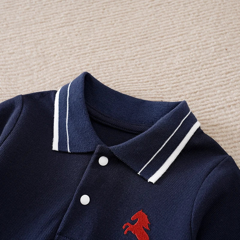 Navy blue polo shirt with white trim and red horse logo on a beige surface