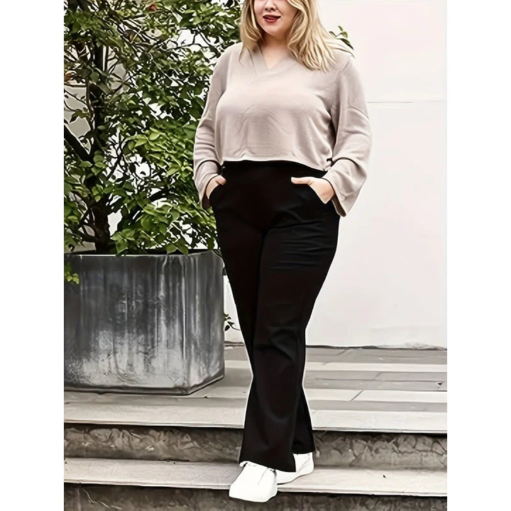 Women's Plus Size Black Pants With A Beige Top And White Sneakers On Outdoor Steps