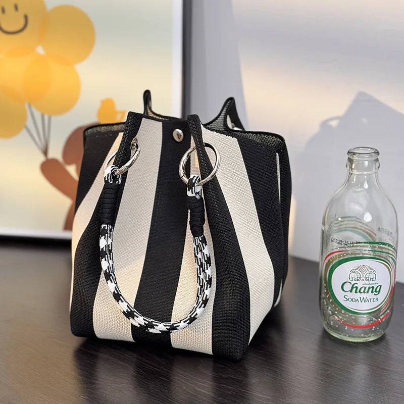 Structured top-handle satchel in black and white vertical stripes with loop handles and metal rings