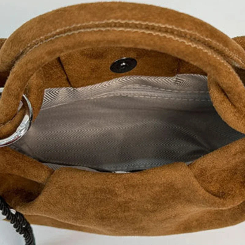 Brown suede mini hobo bag interior view with snap button and patterned lining.