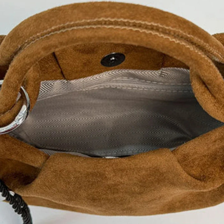 Brown suede mini hobo bag interior view with snap button and patterned lining.