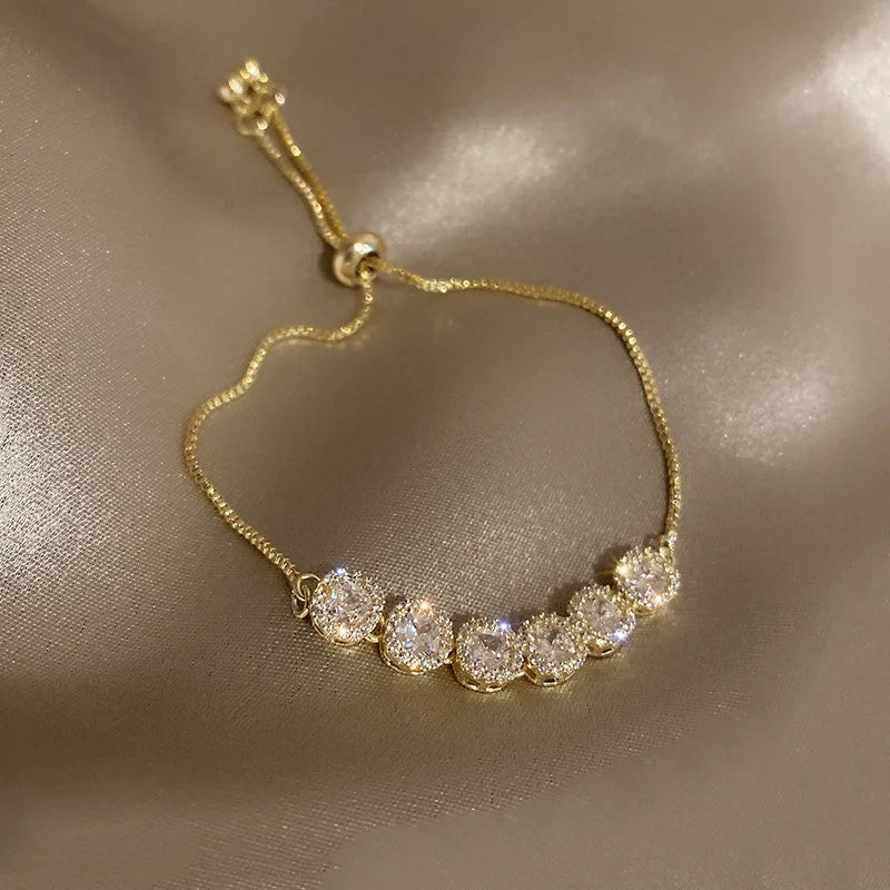 Gold-tone zircon bracelet with round pavé stones on a curved chain