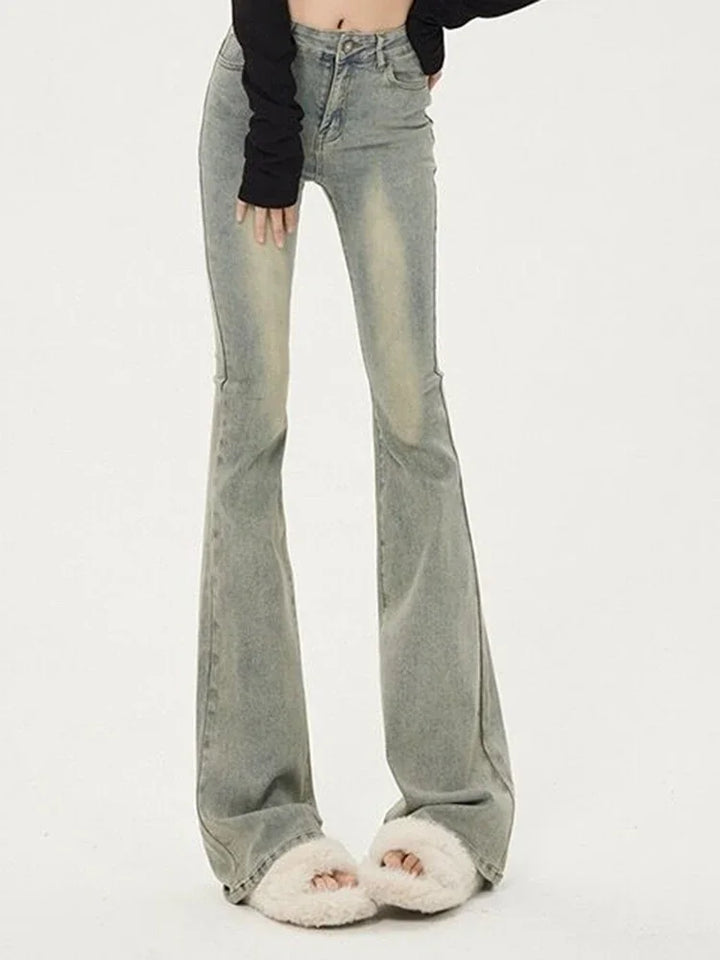 Person wearing light blue flared jeans on a white background