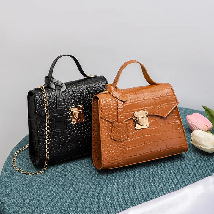 Black and brown crocodile-patterned handbags on a gray background