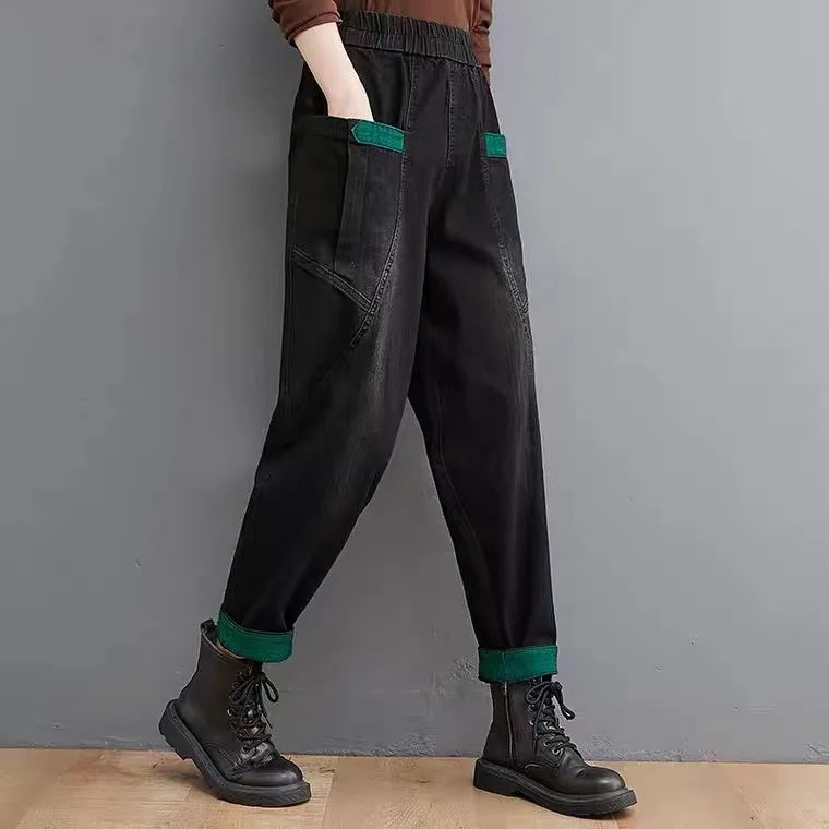 Black pants with green accents worn by a person against a gray background