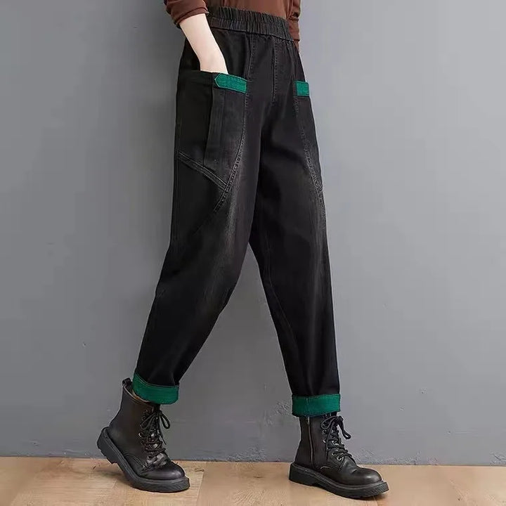 Black pants with green accents worn by a person against a gray background