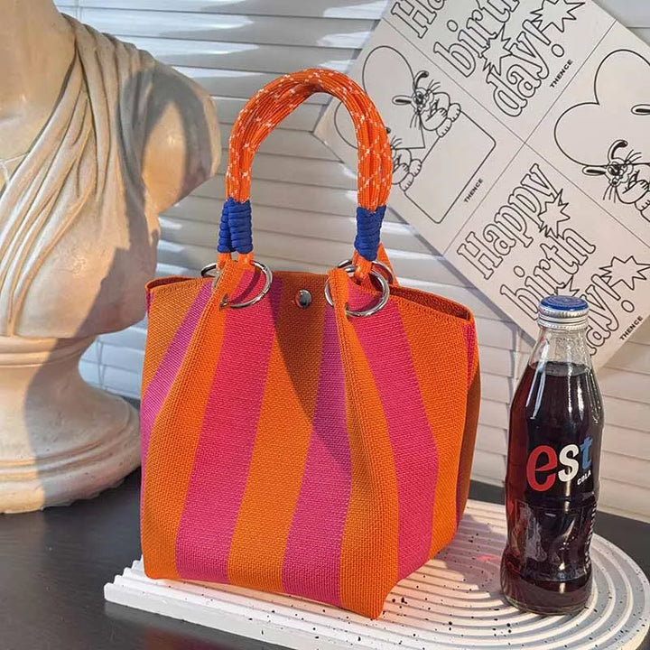 Orange, purple, and magenta striped top-handle satchel with braided handles and metal rings