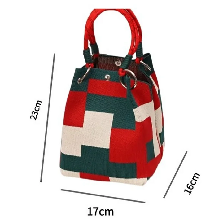 Color-block satchel bag with red top handle and red, green, and cream geometric panels.