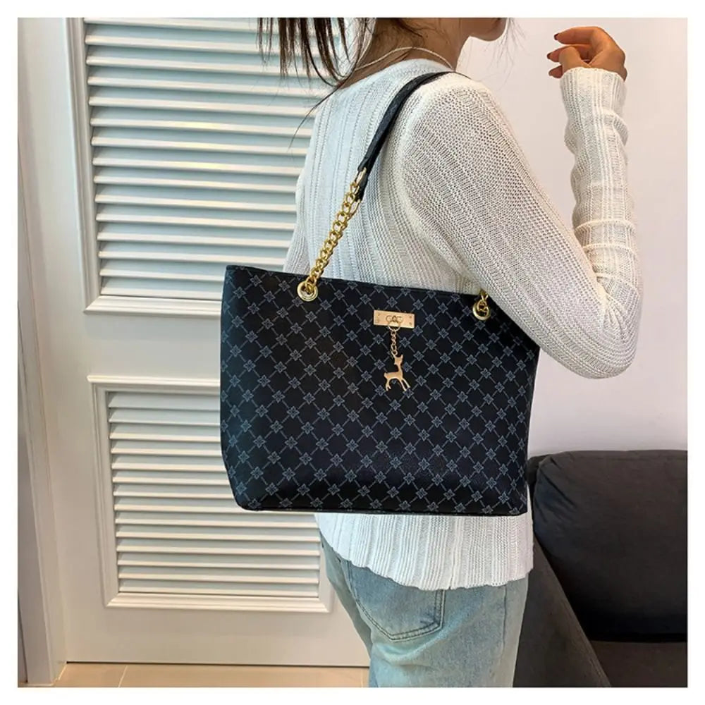 Large patterned bucket tote bag with chain handles and top clasp, dark navy/black