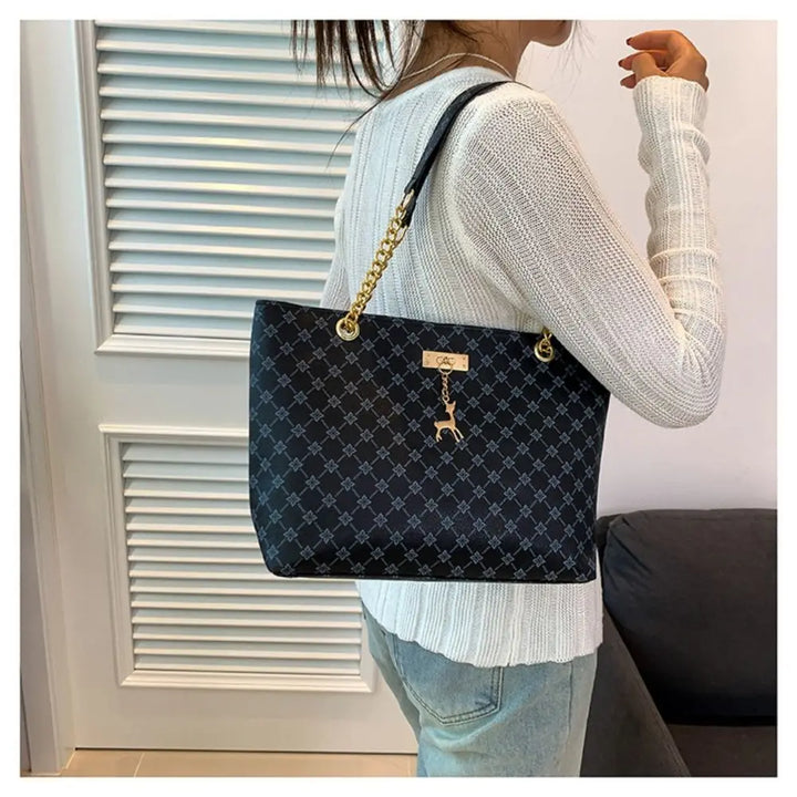 Large patterned bucket tote bag with chain handles and top clasp, dark navy/black