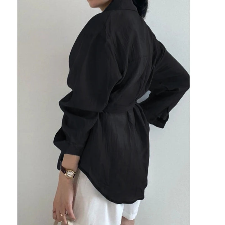 Person wearing a black kimono-style garment against a plain background
