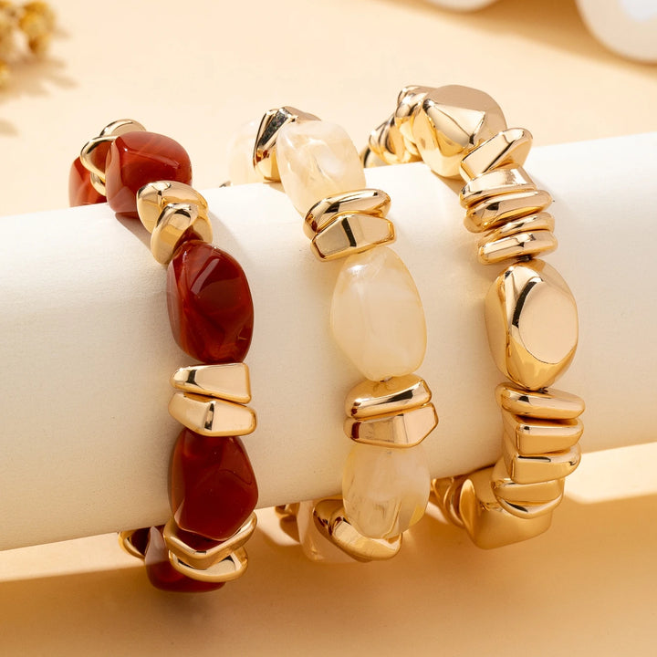 Gold-tone acrylic bead bracelets with red and cream oval beads and chunky link details