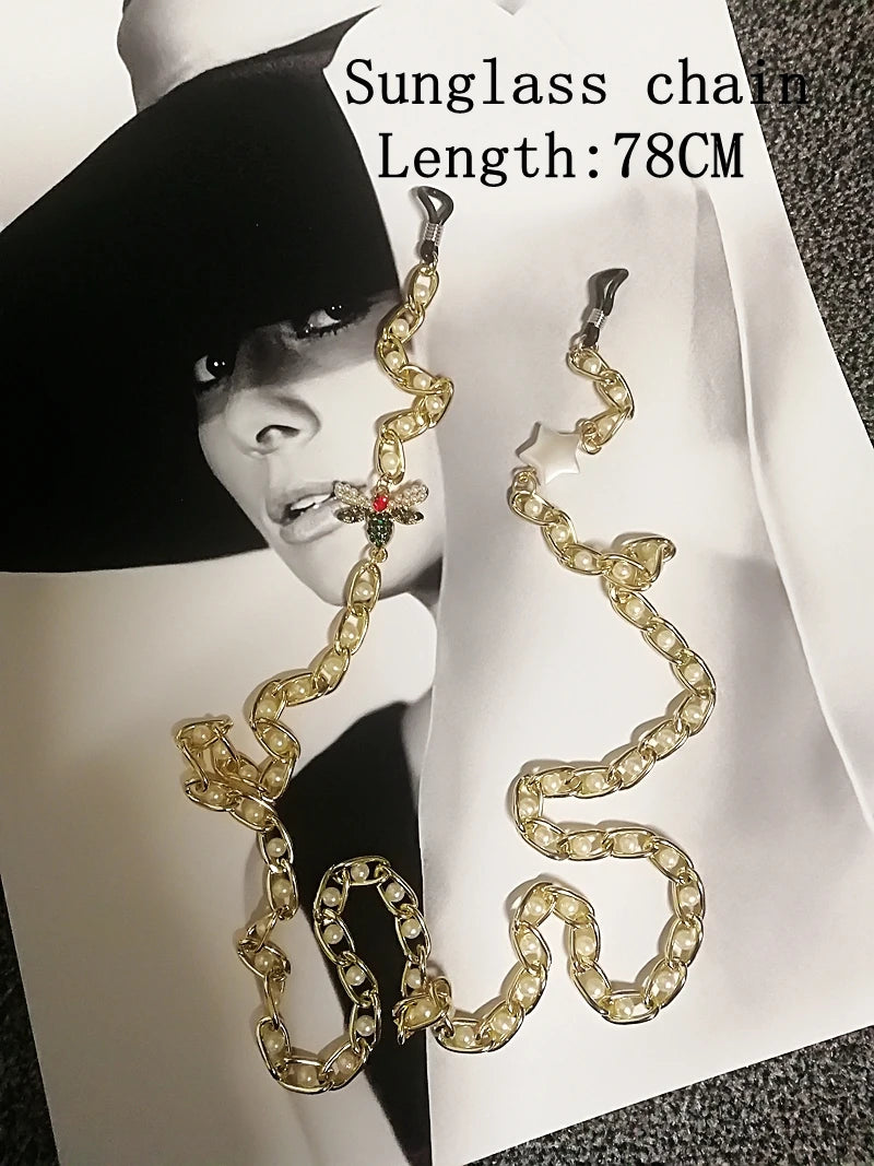 Gold chain sunglasses holder with a model in the background