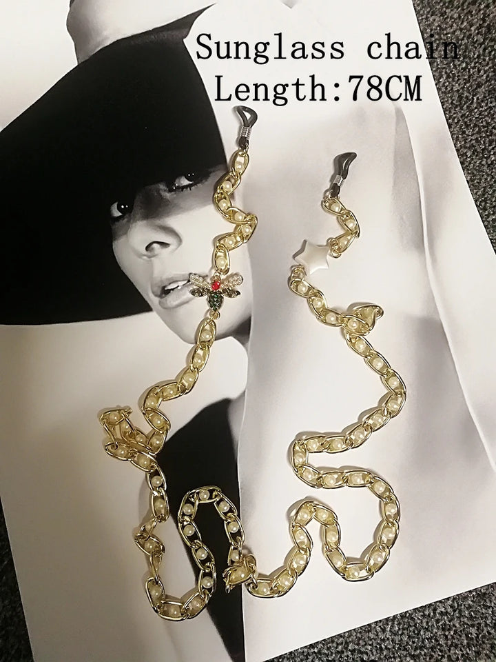 Gold chain sunglasses holder with a model in the background