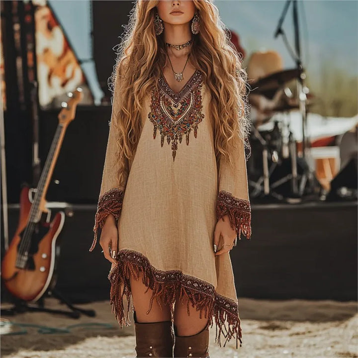 Woman wearing a bohemian dress with fringe details in a music festival setting.