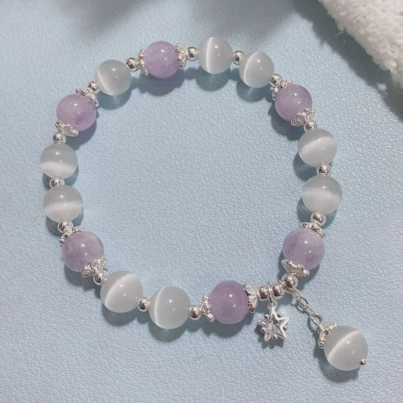 Pastel beaded elastic bracelet with star charm and bell-style dangle accents
