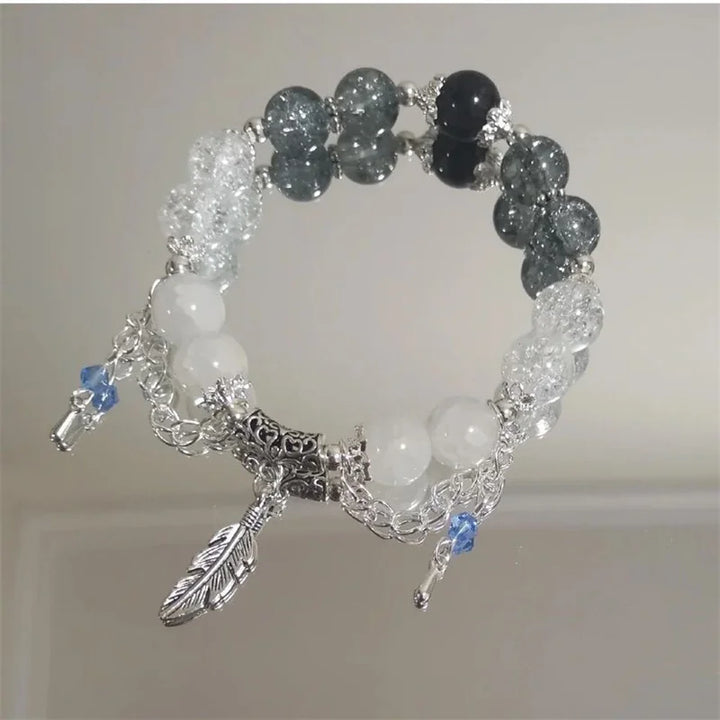 Mixed light and dark bead charm bracelet with silver chain, feather and leaf dangles