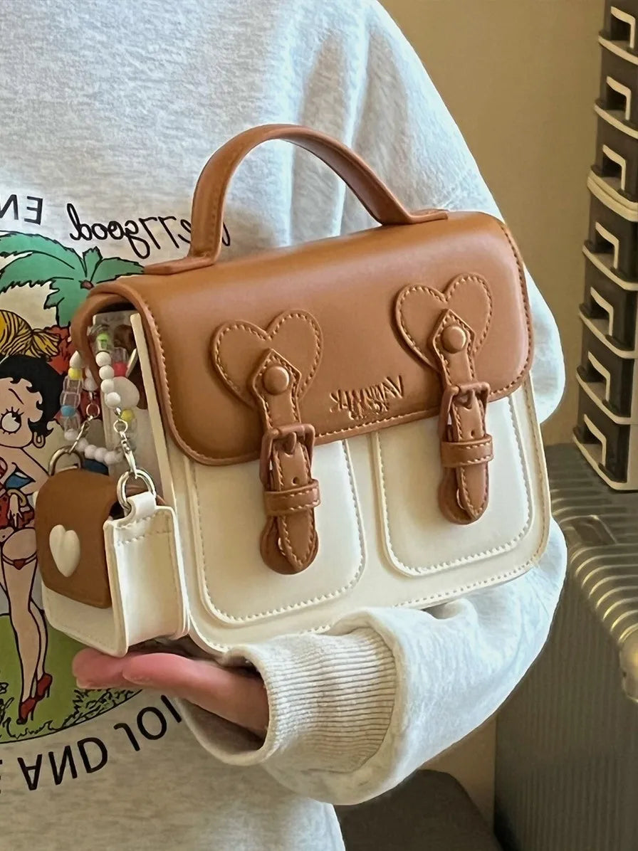 Two-tone women’s shoulder handbag with heart front flap and small earphone pouch charm