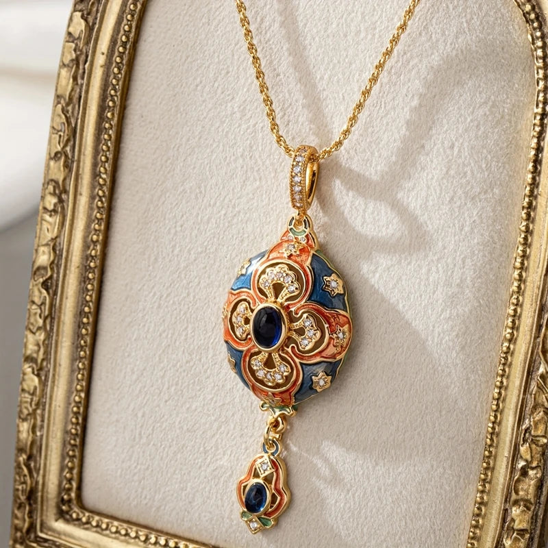 Decorative necklace with a gold chain and intricate pendant on a textured white surface.