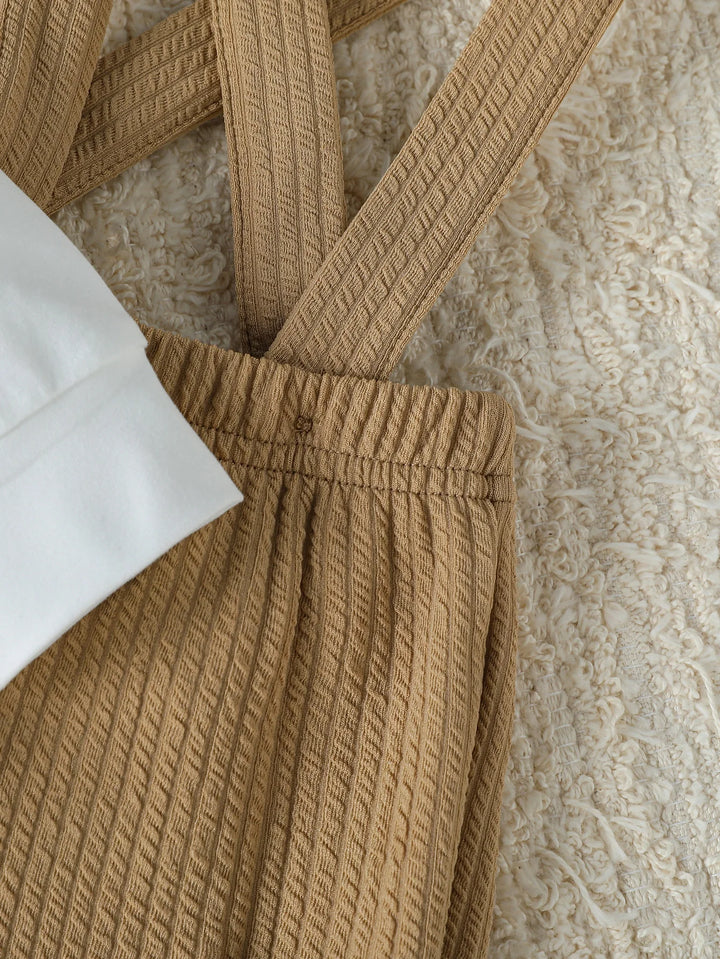 Close-up of a brown textured garment with a white fabric underneath on a neutral background