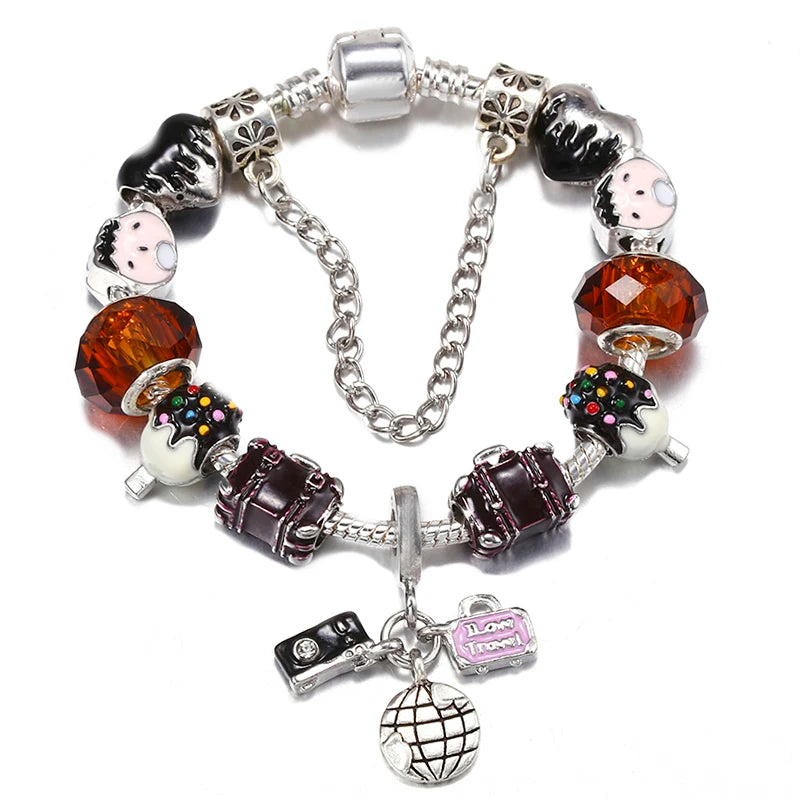 Silver charm bracelet with black enamel charms, orange faceted bead, and globe heart pendant