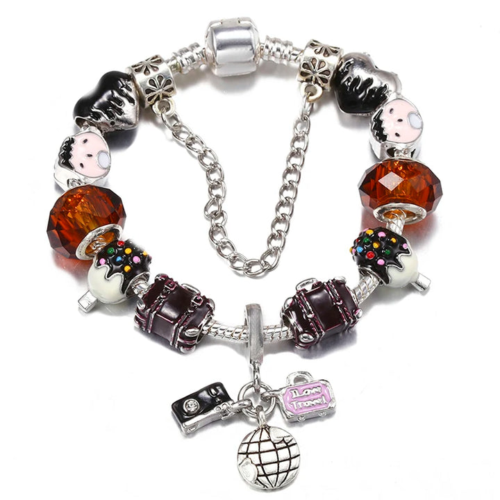 Silver charm bracelet with black enamel charms, orange faceted bead, and globe heart pendant
