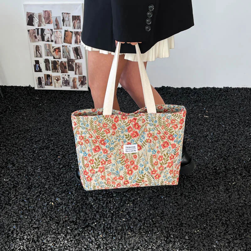 Canvas tote bag with red and blue floral print and light top handles