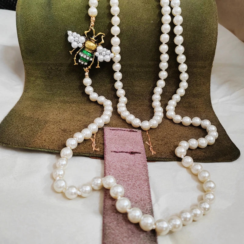 Pearl necklace with a decorative pendant on a green cushion