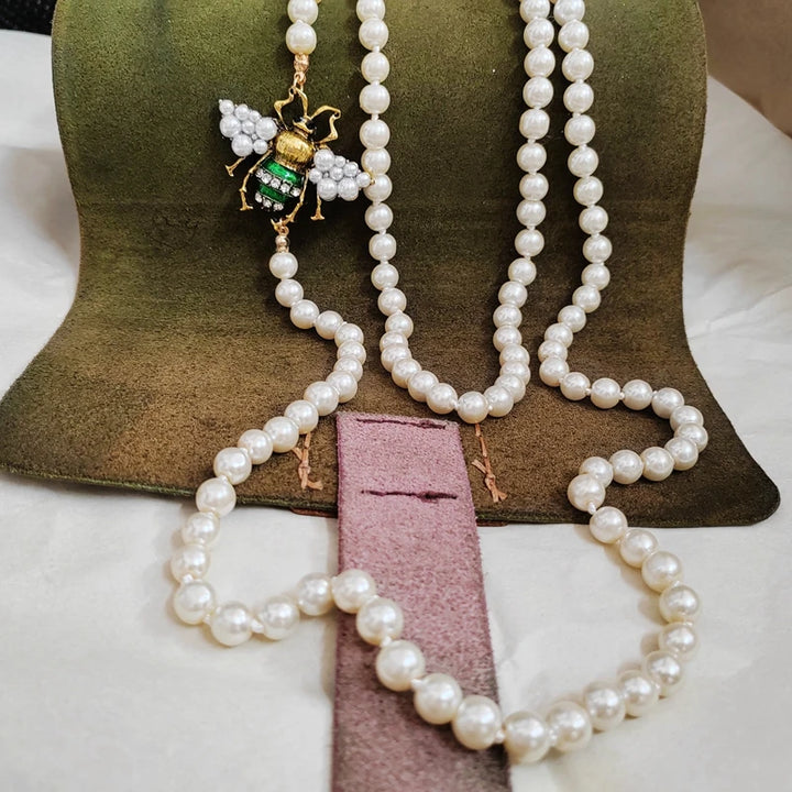 Pearl necklace with a decorative pendant on a green cushion