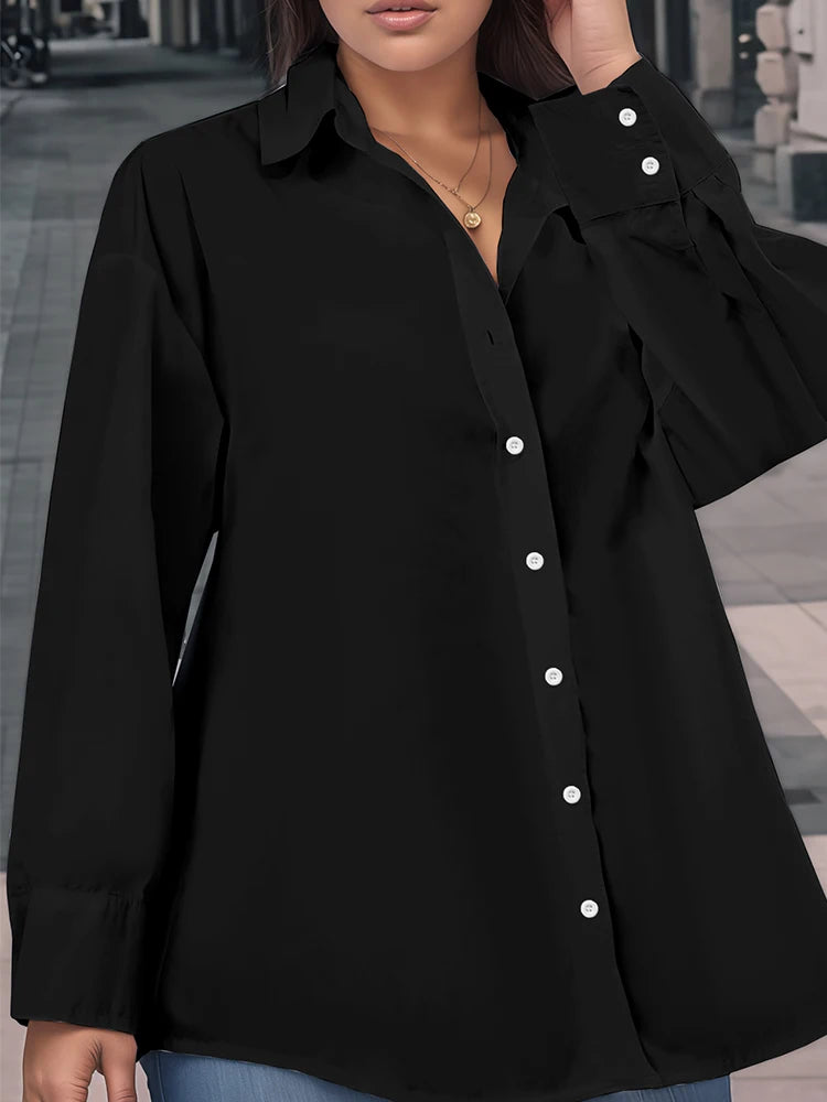 Black button-up shirt worn by a person with a blurred indoor background