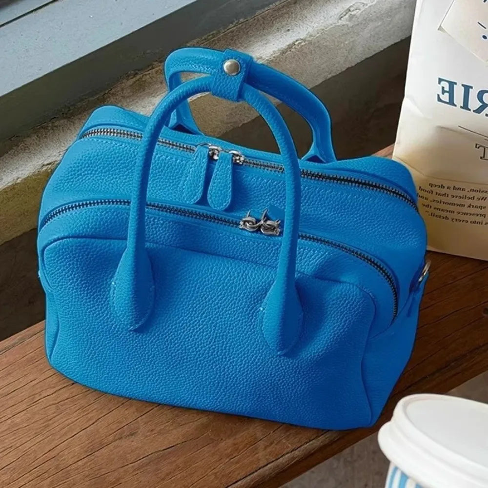 Blue handbag on a wooden surface with a blurred background