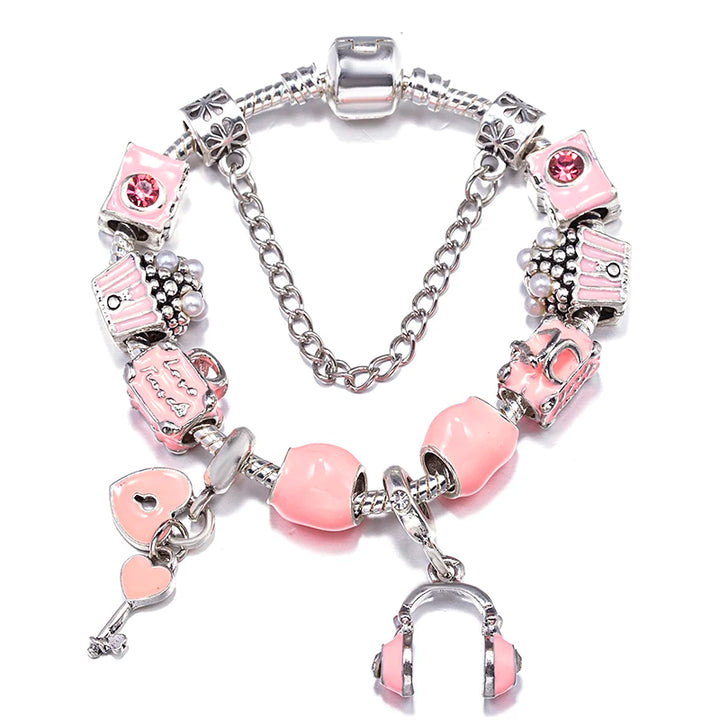Silver charm bracelet with pink beads, rhinestone accents, and small hand-sculpture charms